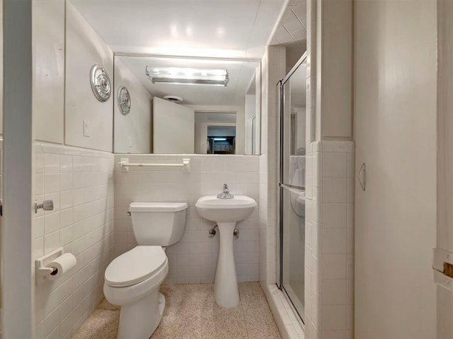 1946 Southview Cir, Center, TX 75935 - bathroom featuring tile walls, a stall shower, toilet, and wainscoting