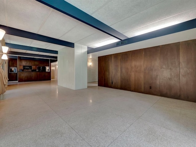 1946 Southview Cir, Center, TX 75935 - unfurnished room featuring speckle patterned floor, wooden walls, and beamed ceiling