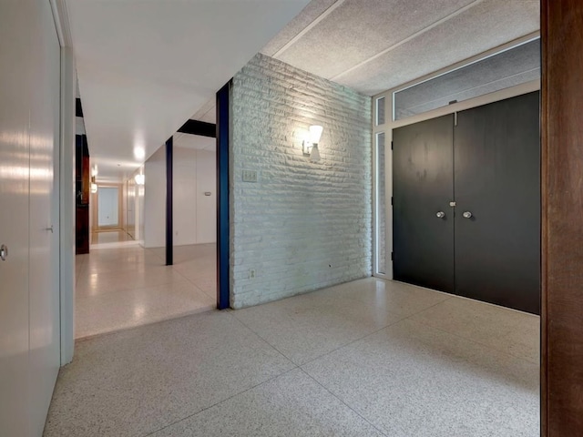 1946 Southview Cir, Center, TX 75935 - interior space with speckle patterned floor and brick wall