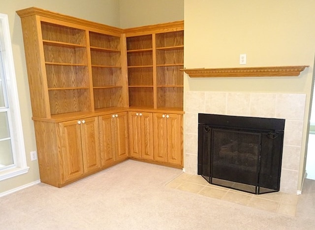 unfurnished living room with light carpet and a tile fireplace