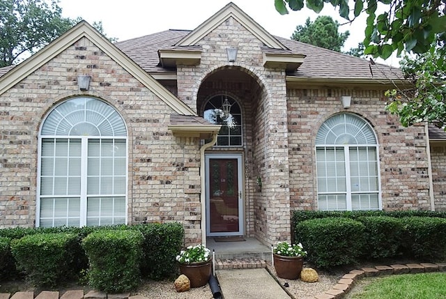 4805 Champions Dr, Lufkin, TX 75901 - view of exterior entry featuring brick siding and a shingled roof
