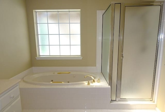 bathroom with vanity and shower with separate bathtub