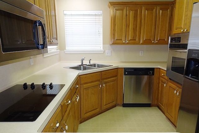 4805 Champions Dr, Lufkin, TX 75901 - kitchen with stainless steel appliances, a sink, brown cabinets, and light countertops