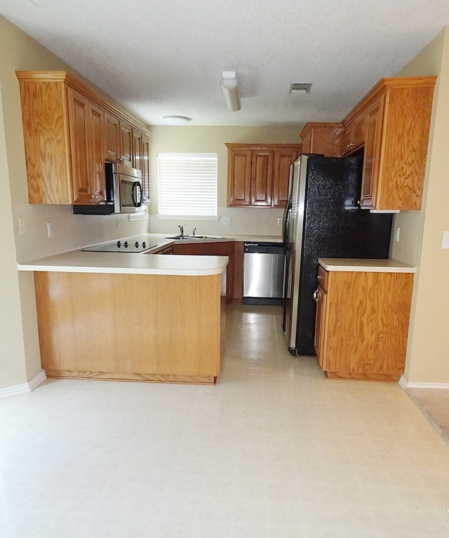 4805 Champions Dr, Lufkin, TX 75901 - kitchen featuring stainless steel appliances, a peninsula, light countertops, a sink, and baseboards