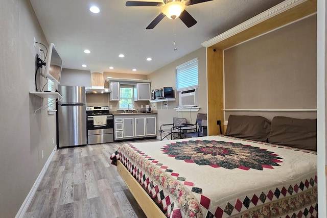 bedroom featuring ceiling fan, sink, stainless steel refrigerator, and light hardwood / wood-style flooring