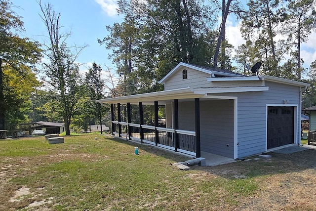 view of side of home featuring a porch, a garage, and a lawn