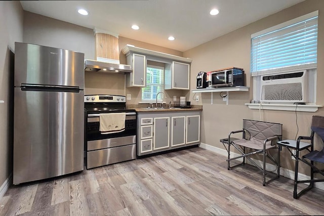 kitchen featuring white cabinets, stainless steel appliances, range hood, and light hardwood / wood-style floors