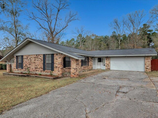 ranch-style house featuring a garage and a front yard