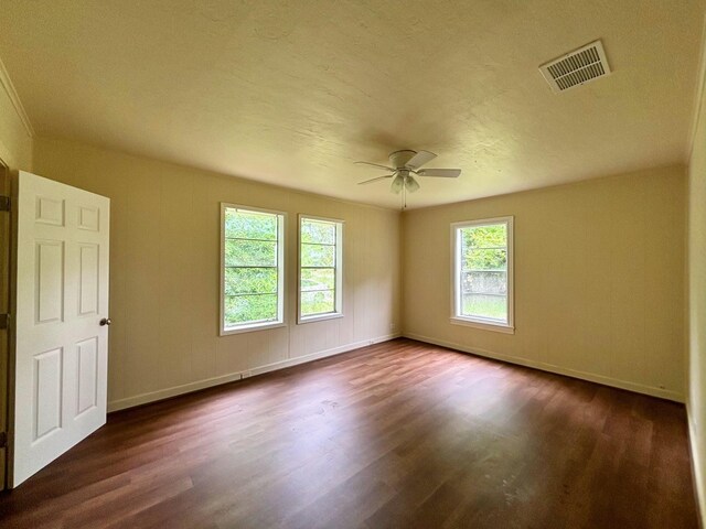 empty room with a textured ceiling, dark hardwood / wood-style flooring, and ceiling fan