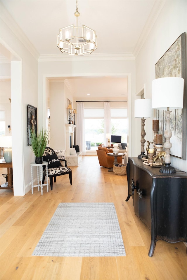 hall with wood-type flooring, a notable chandelier, and ornamental molding