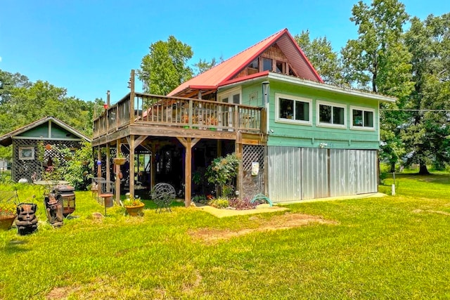 rear view of house with a deck and a yard