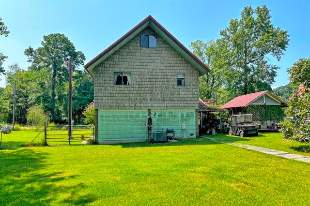 rear view of property featuring cooling unit and a yard