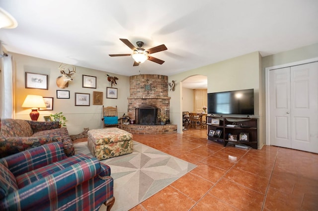 309 Echo Ln, Lufkin, TX 75904 - living room featuring arched walkways, ceiling fan, tile patterned flooring, and a brick fireplace