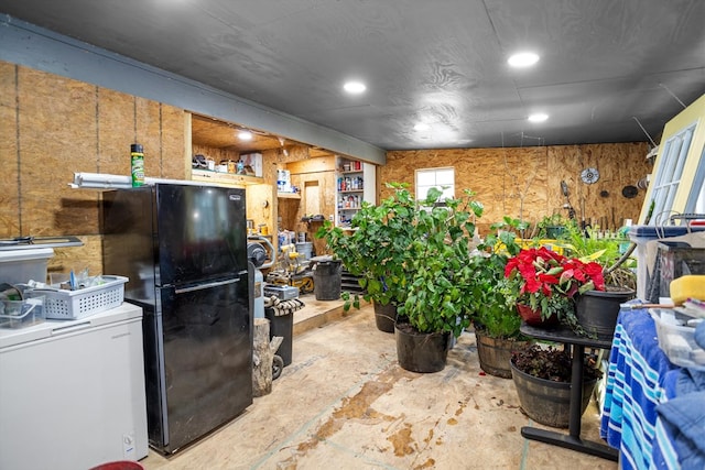 kitchen with concrete floors, black fridge, and fridge