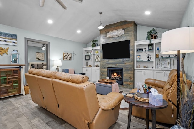 living room with a fireplace, light wood-type flooring, ceiling fan, and lofted ceiling