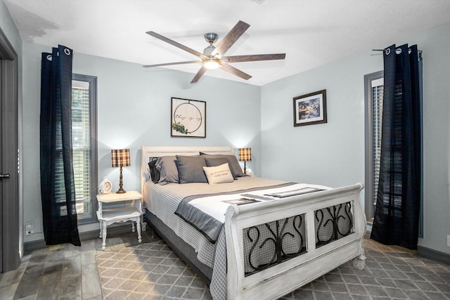 bedroom with multiple windows, ceiling fan, and hardwood / wood-style flooring