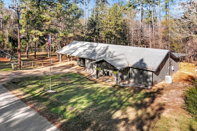 view of front of property featuring a front yard, central AC, and a carport