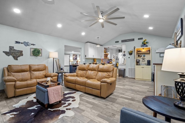 living room featuring ceiling fan, light wood-type flooring, and lofted ceiling