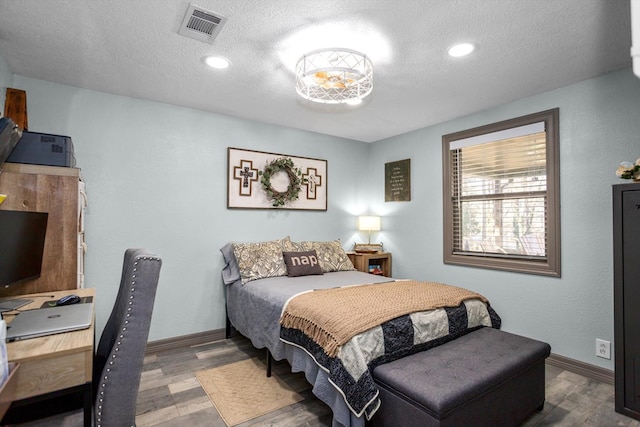 bedroom featuring hardwood / wood-style floors and a textured ceiling