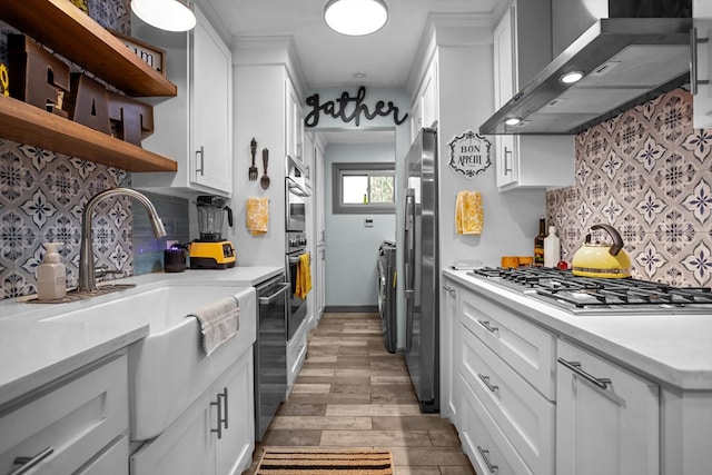 kitchen featuring white cabinets, wall chimney range hood, and tasteful backsplash