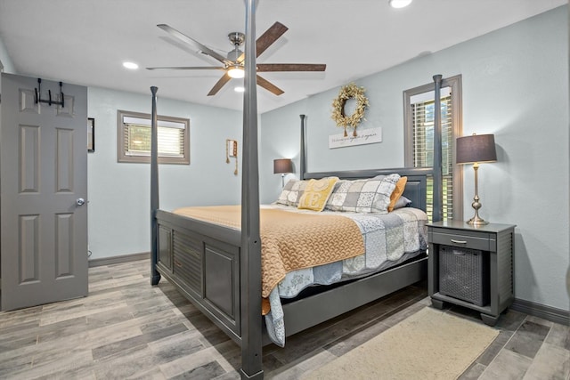 bedroom featuring multiple windows, hardwood / wood-style floors, and ceiling fan