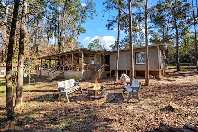 back of house featuring an outdoor fire pit