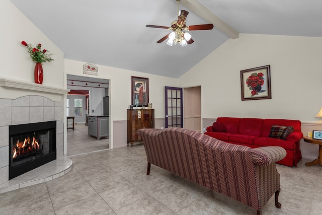 living room featuring lofted ceiling with beams, ceiling fan, light tile patterned floors, and a tile fireplace