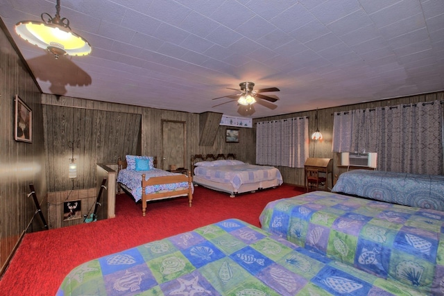 bedroom with ceiling fan, carpet floors, and wooden walls