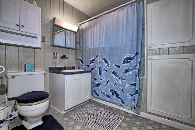 bathroom with a shower with shower curtain, vanity, toilet, and wooden walls