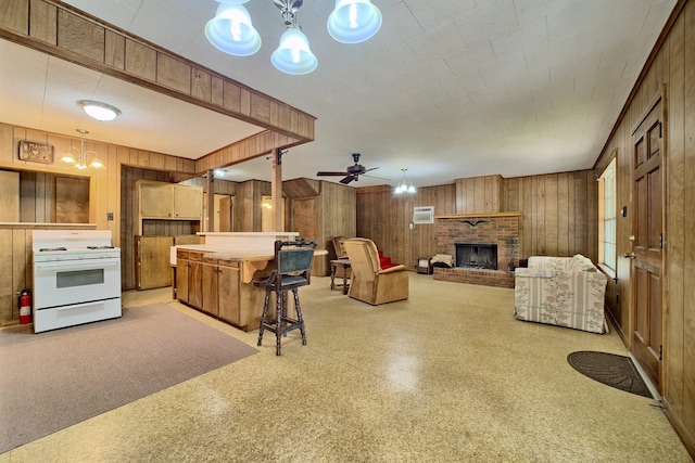 living room featuring a fireplace, ceiling fan, and wooden walls