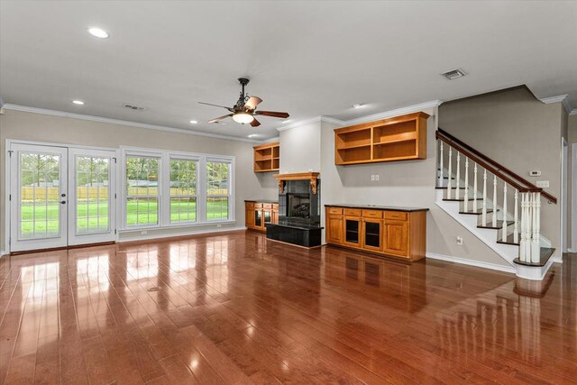 unfurnished living room with a fireplace, ceiling fan, crown molding, and wood-type flooring