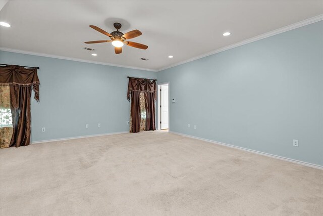 carpeted spare room featuring ceiling fan and crown molding