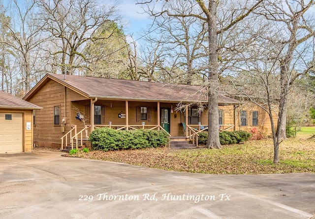 single story home featuring a garage and a porch