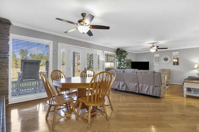 dining space featuring hardwood / wood-style flooring, ceiling fan, crown molding, and french doors