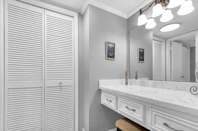 bathroom with vanity, ornamental molding, and a chandelier