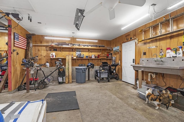 garage featuring a workshop area, ceiling fan, and wooden walls