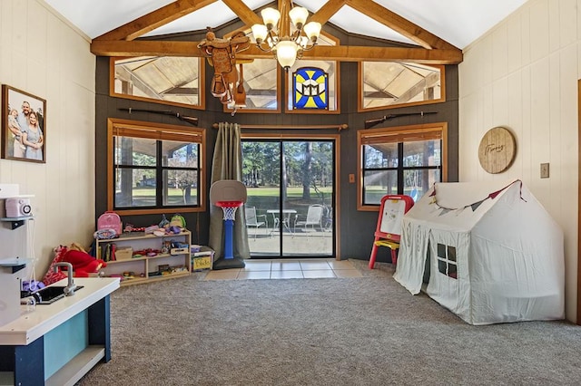 rec room featuring lofted ceiling with beams, light colored carpet, an inviting chandelier, and wooden walls