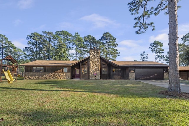 view of front facade featuring a playground, a garage, and a front lawn