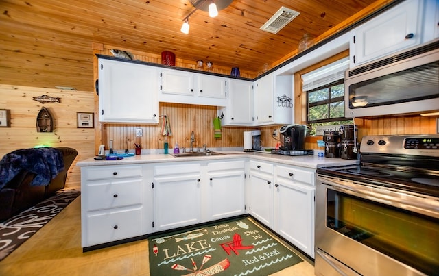 kitchen featuring appliances with stainless steel finishes, white cabinetry, wooden ceiling, and wood walls