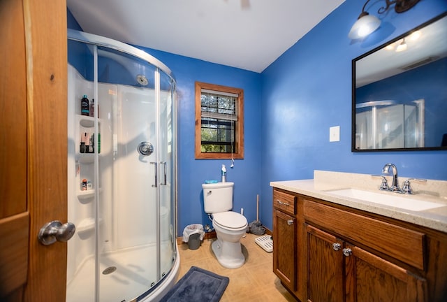 bathroom with vanity, toilet, and a shower with door