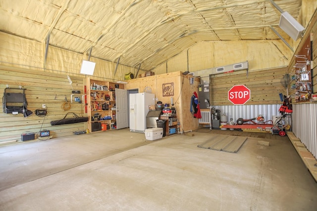 garage with a workshop area and white refrigerator with ice dispenser