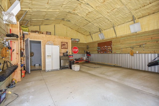 garage featuring white refrigerator with ice dispenser