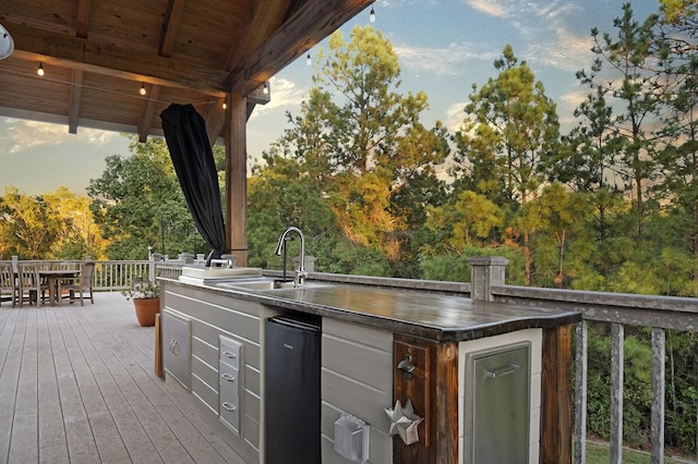 deck at dusk with exterior kitchen and sink