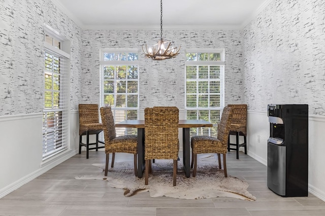 dining area featuring ornamental molding, light wood-type flooring, and a notable chandelier