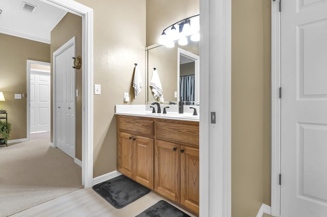 bathroom with crown molding and vanity