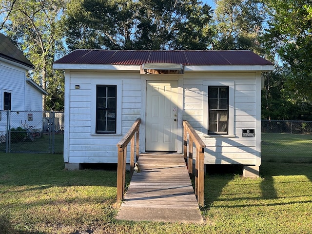 view of front facade featuring a front lawn and a storage shed