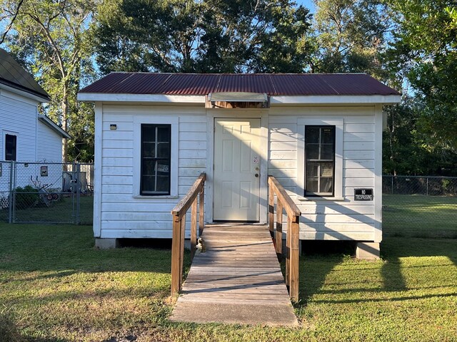 view of front of property with solar panels, covered porch, and a front yard