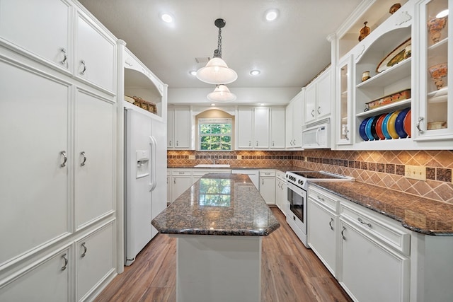 kitchen with white cabinets, white appliances, dark hardwood / wood-style floors, and a kitchen island