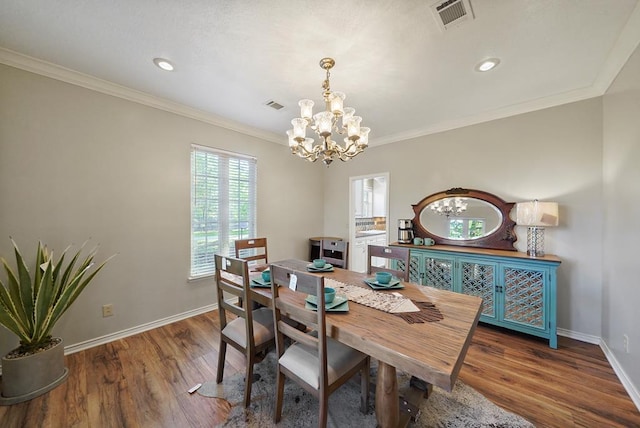 dining room with an inviting chandelier, dark wood-type flooring, and crown molding