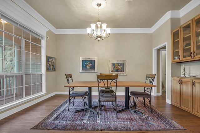 dining room featuring ornamental molding, dark wood-type flooring, and a notable chandelier